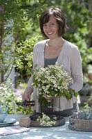 Woman with tea herbs bouquet from Matricaria chamomilla