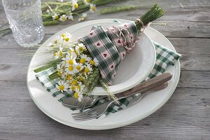 Small bouquet of camomile (Matricaria chamomilla) and ears of barley