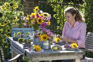 Table decoration with sunflowers, decorative baskets and apples