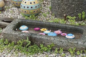 Getöpferte Schwimmkugeln schwimmen in Granit-Trog