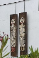 Getöpferte Figuren auf Holzbohlen aufgehängt