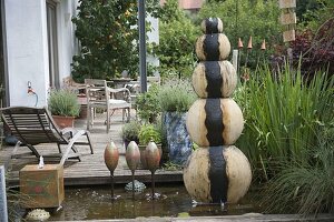 Various hand-potted water features in an architectural pond