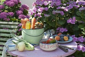 Frisch geerntetes Gemüse und Obst auf Gartentisch