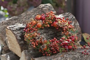 Wreath of mixed pinks (rose hips) on firewood piles