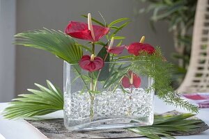 Modern arrangement with anthurium (flamingo flowers), palm leaf