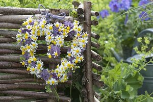 Kränzchen in Herzform aus Kamille (Matricaria chamomilla) und Blüten