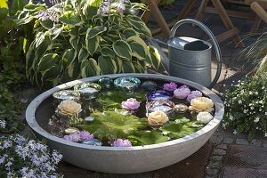 Bowl of floating rose petals and candles