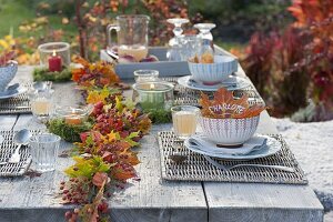 Herbstliche Tischdeko mit Girlande aus Herbstlaub und Hagebutten