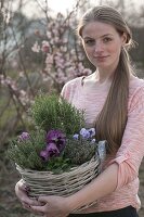 Frau trägt Korb mit Rosmarin (Rosmarinus), Thymian (Thymus vulgare)