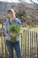 Frau mit Muscari siberica (Traubenhyazinthen) im Korb