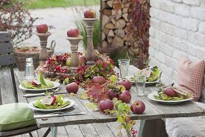 Tischdeko mit Äpfeln, Hagebutten und wildem Wein