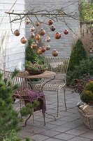 Weihnachtliche Terrasse mit kupfernen Kugeln am Zweig