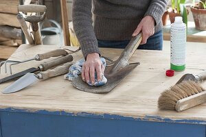 Garden tools clean, woman cleans spade with gun oil