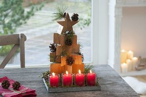 Stacked wooden stars as a fir tree, cones and branches