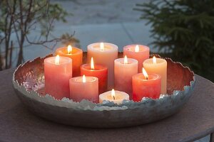 Candles in copper bowl on patio table