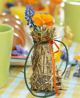 Osterfrühstück: Reagenzglas mit Blüten, Stroh umwickelt
