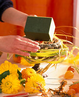 Iron bowl with an arrangement of dahlias (Dahlia), lantern flower (Physalis), sea buckthorn (Hippophae)