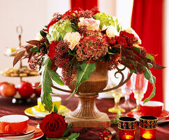 Iron amphora with autumnal arrangement of carnations and hydrangeas