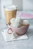 Vegan coconut balls with birch sugar next to a latte macchiato