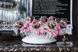 Vegane Cake Pops in Klarsichtfolie gewickelt als Geschenk in Ständer