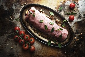Raw pork fillet with mushrooms and tomatoes