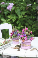 Autumn posies made from asters, globe thistles and rose hips in vases with felt covers