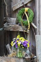 Blumenstrauß im Einmachglas und ein Kranz aus Rapsschoten