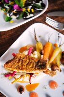 Perch on a bed of carrots and chard served at the 'Oberstübchen' restaurant next to the ECF Farm in Berlin, Germany