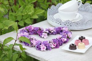 Herz aus Hortensienblüten und Phlox auf dem Tisch im Garten