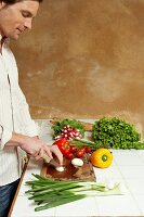 Man chopping vegetables in a kitchen