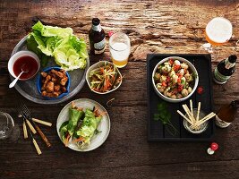 Verschiedene Vorspeisen, Salat und Bier auf Holztisch