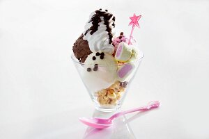 An ice cream sundae with sweets and cream