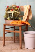 Arrangement of bilberry twigs and ranunculus on old chair