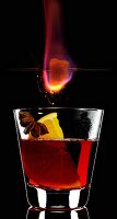 A burning sugar cube over a glass of Feuerzangenbowle