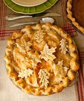 Homemade apple pie with pastry elm and maple leaves