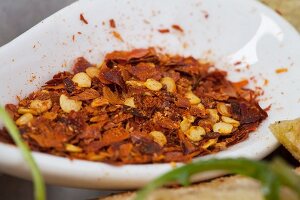Crushed chillies in a ceramic bowl (close-up)