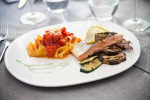 Tagliatelle with tomatoes and a salmon fillet with grilled vegetables