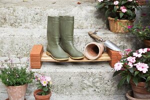 Wellington boots and plant pot on DIY cane shoe rack on stone steps