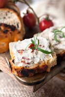 Fresh cheese with dried tomatoes and herbs on tomato bread