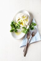 Frischer Burrata mit Olivenöl und Feldsalat in Keramikschale