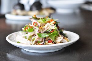 Hähnchensalat mit Gemüse und Kräutern auf Teller