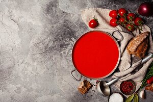Tomato soup in a rustic bowl on grey stone background