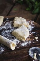Ricotta gnocchi on a wooden board being rolled