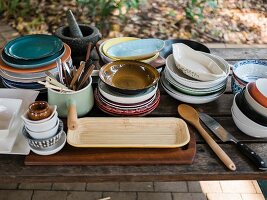 A collection of crockery on a wooden table outdoors