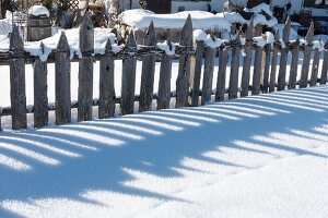 Wooden garden fence in snow