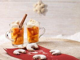 Apple punch with cinnamon and cream in glasses, with vanilla horn biscuits