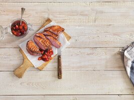 Grilled duck breast with chutney on a wooden board