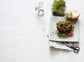 A teriyaki burger with mushrooms, spring onion and cress