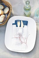 A cutlery pouch made of a paper sandwich bag on a garden table