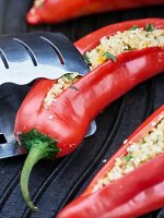 Red peppers stuffed with bulgur wheat and herbs on a grill